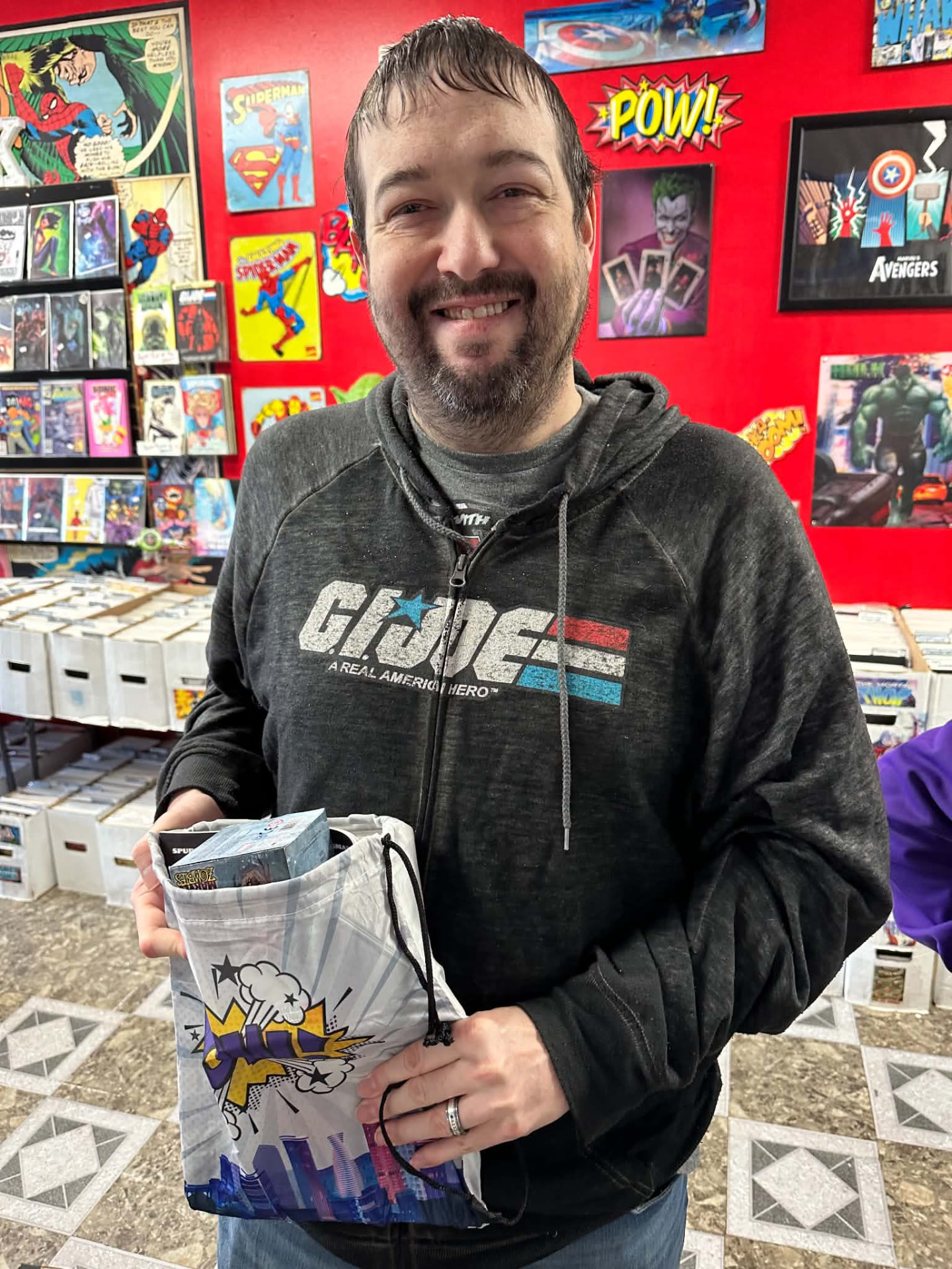 A customer holding a white Pow swag bag with toys stacked inside