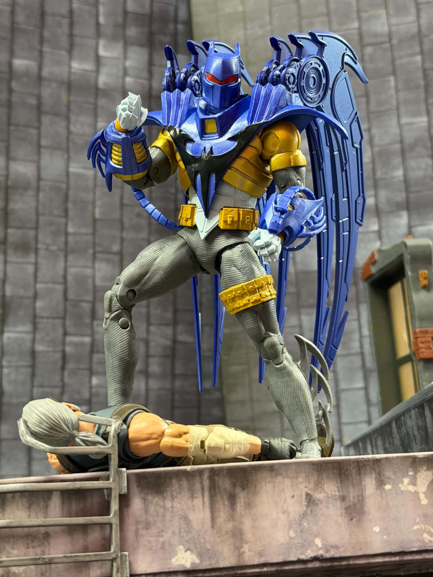 An armored knight figure with mechanical wings standing over a fallen opponent