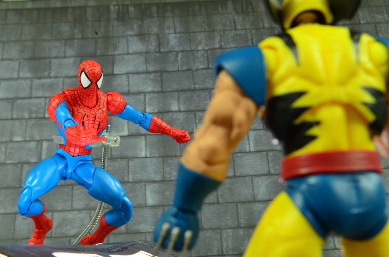 A web-slinger figure facing off against a clawed brawler in a brick alley