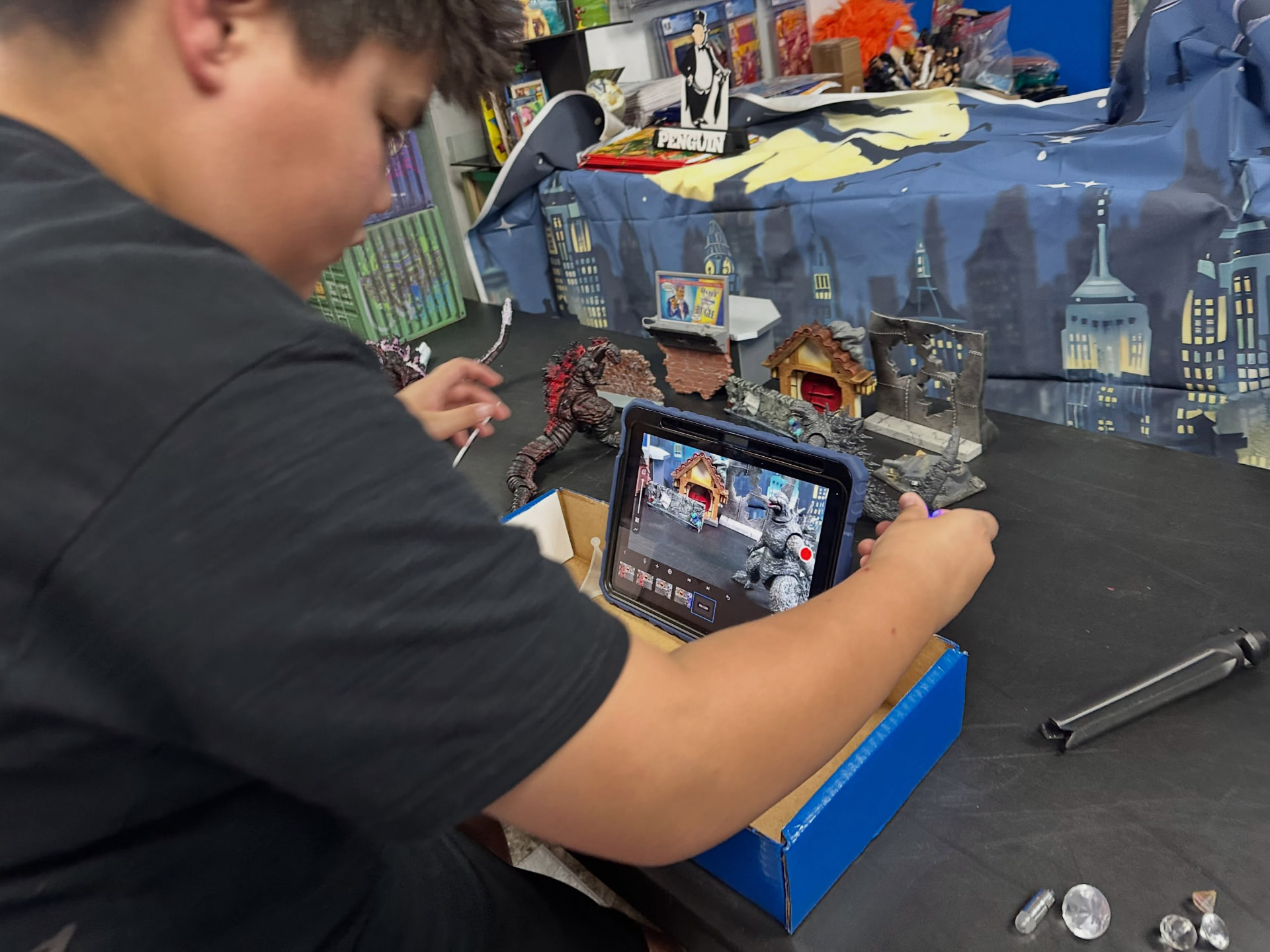 Stop-motion animation in progress with monster figures and a tablet