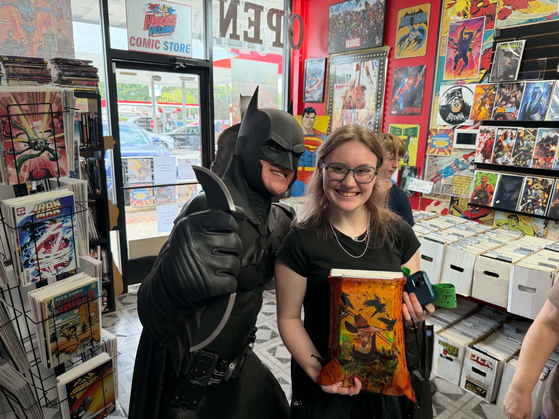 Batman arm in arm with a smiling fan holding a Scarecrow drawstring bag