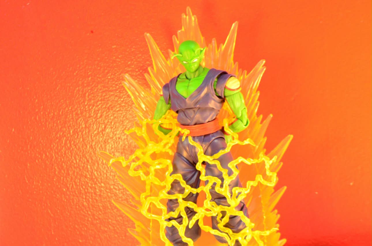 A green martial-arts alien figure crackling with yellow energy effects