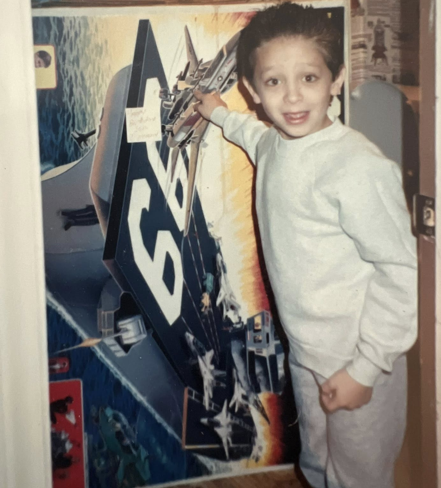 A young Manny-Mac with his favorite poster — a lifelong comic fan