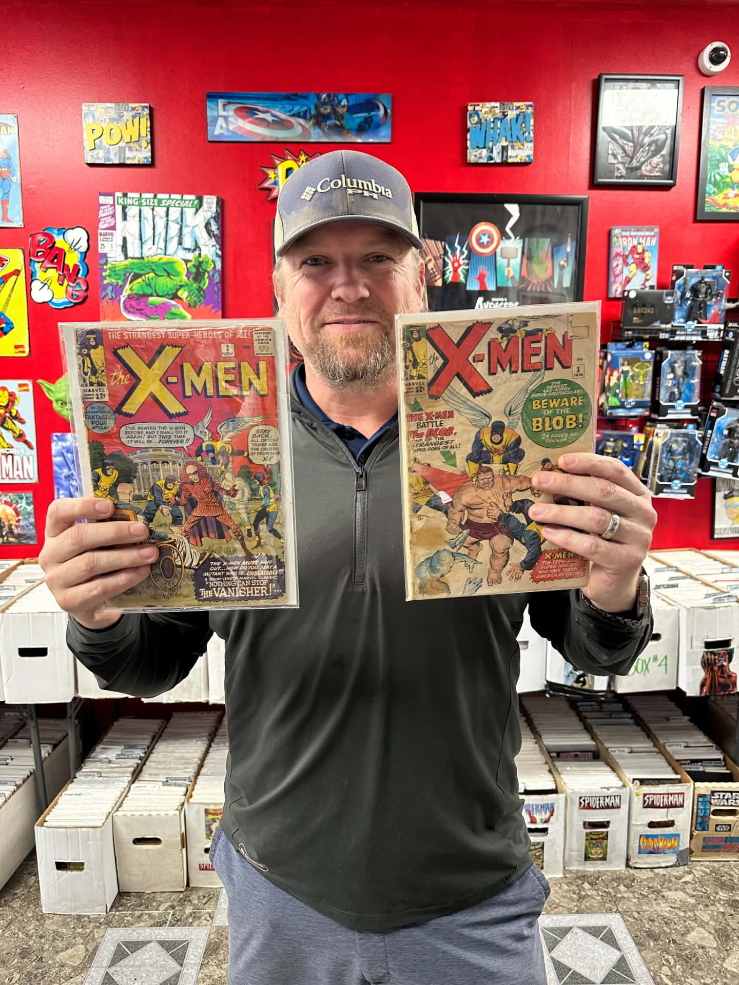 A customer showing off two silver-age X-Men issues inside the shop